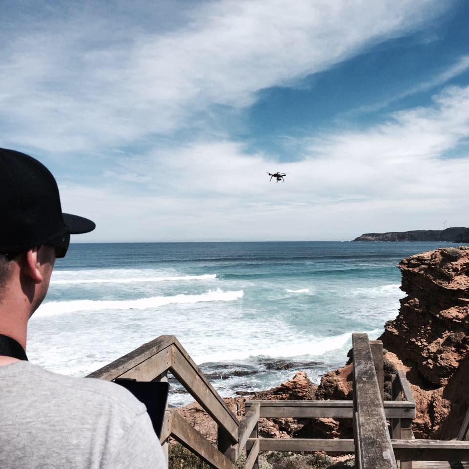 Man flying drone over ocean